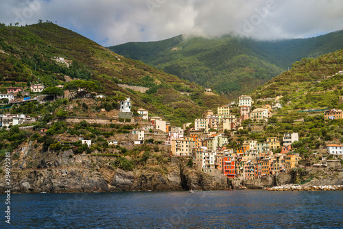 Obraz na płótnie Riomaggiore, Cinque Terre, Italy - August 17, 2019: Village by the sea bay, colorful houses on the rocky coast. Nature reserve resort popular in Europe. w salonie