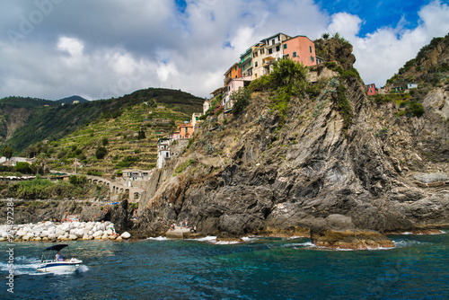 Cinque Terre, Italy - August 17, 2019: Boat trip along the Ligurian coast. Mountain landscape with residential buildings.