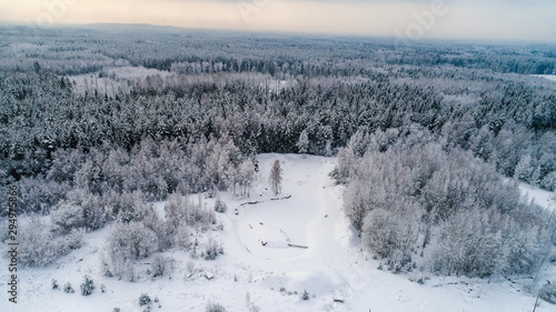 Aerial view of snow covered forest and a road.