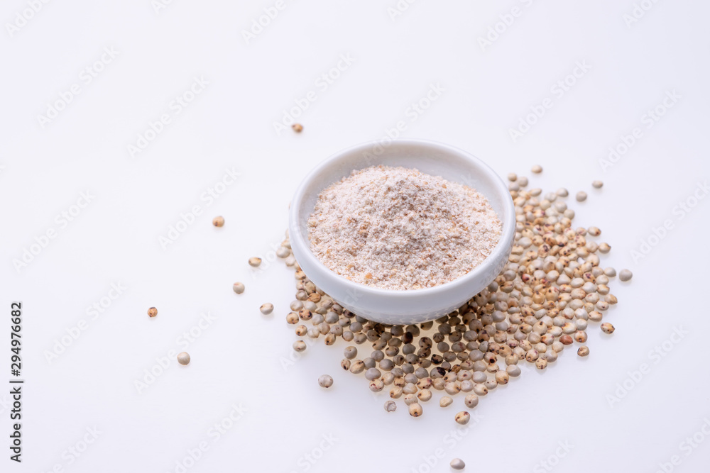 Uncooked raw Sorghum flour (also known as sorgo) in a white bowl, isolated on white background Uncooked raw Sorghum flour (also known as sorgo) in a white bowl, isolated on white background