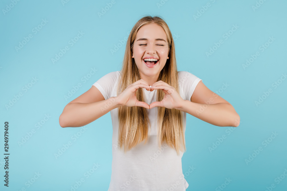 beautiful blonde woman showing heart with hands isolated over blue beautiful blonde woman showing heart with hands isolated over blue