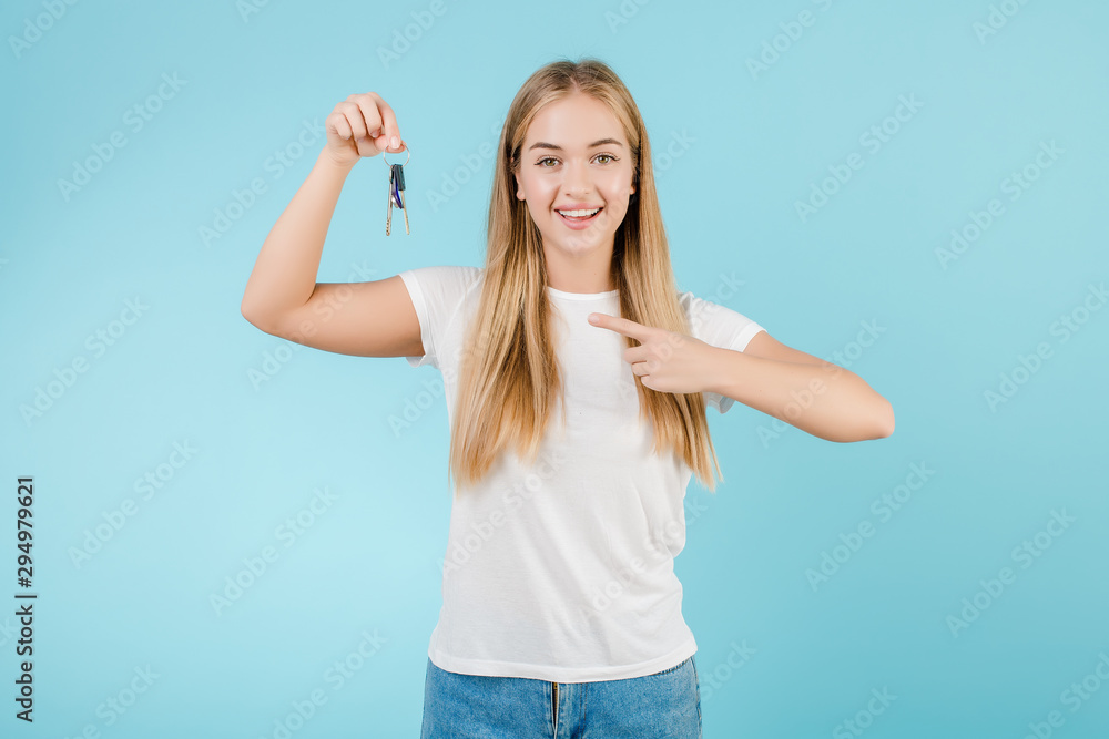 happy smiling blonde woman with keys from apartment isolated over blue - obrazy, fototapety, plakaty 