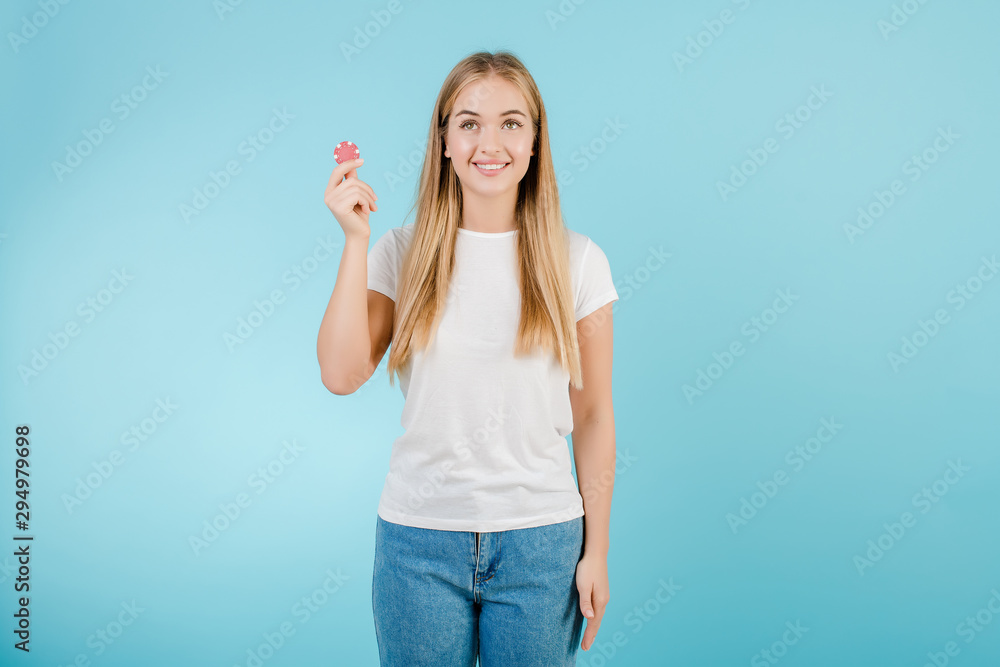 beautiful smiling blonde woman with poker chip from online casino isolated over blue beautiful smiling blonde woman with poker chip from online casino isolated over blue