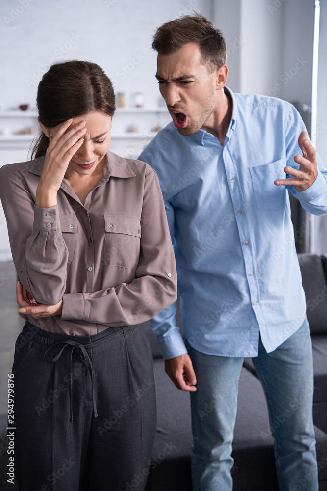 aggressive man in shirt screaming at scared wife at home aggressive man in shirt screaming at scared wife at home