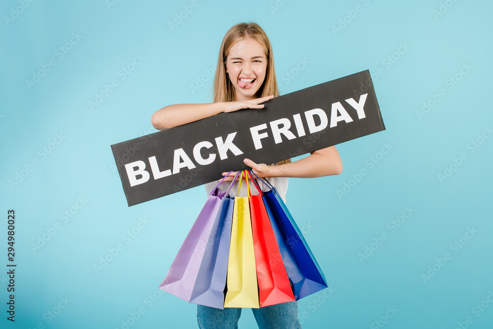 funny girl with black friday sign and colorful shopping bags isolated over blue funny girl with black friday sign and colorful shopping bags isolated over blue
