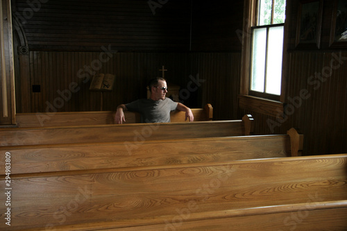 Man sitting in vintage church pews