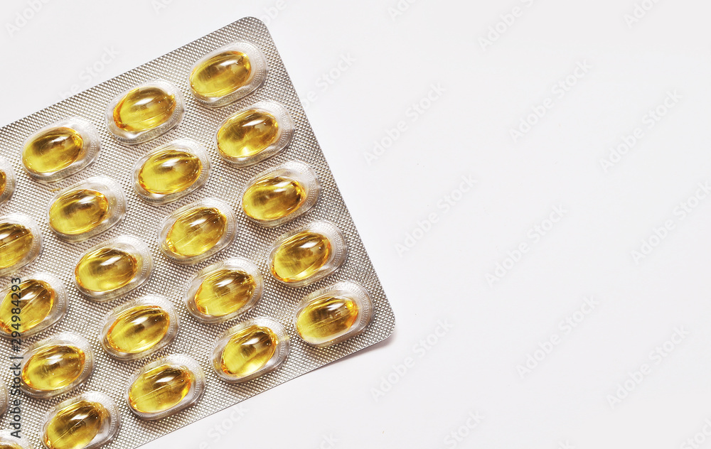 Fish fat in capsule on light background. Fish fat in capsule on light background.
