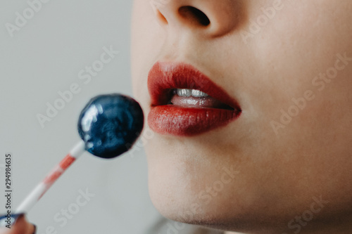 woman's mouth with a lollipop in her hands