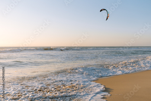 Man kitesurfing at Scarborough Beach as the sun sets over the ocean in the distance. 