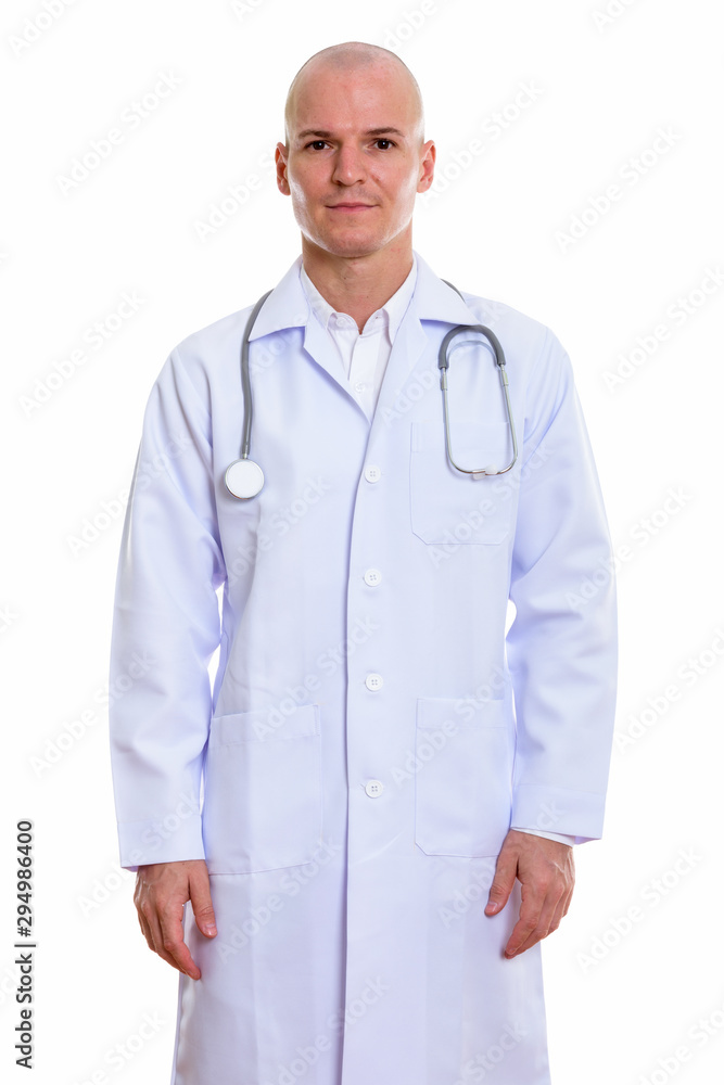 Studio shot of young handsome bald man doctor standing Studio shot of young handsome bald man doctor standing