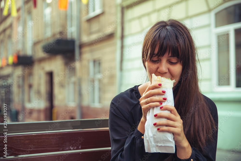 young smiling woman eating fast food outdoors young smiling woman eating fast food outdoors