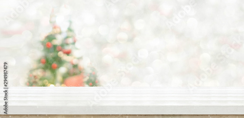 Empty white wood table top with abstract warm living room decor with christmas tree string light blur background with snow Holiday backdrop Mock up banner for display of advertise product