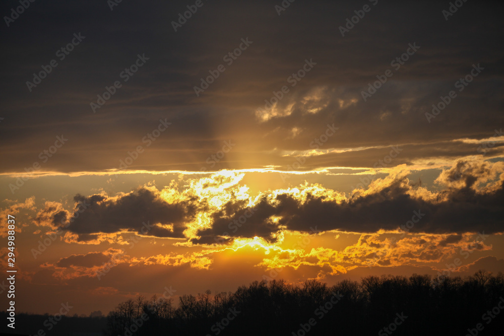 Sunrise behind clouds with reflection off upper layers
