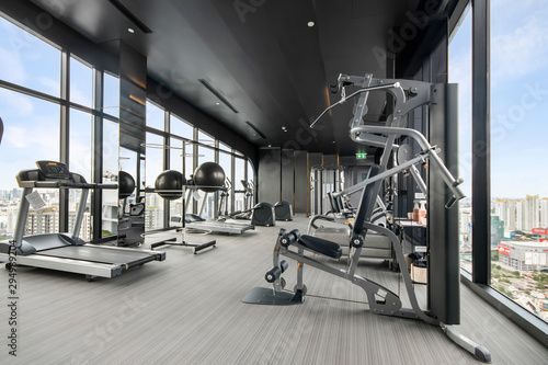 Fitness gym and Treadmill, Chest press machine equipment at sky view, on top modern condominium, Room is glazed and has lots of windows.