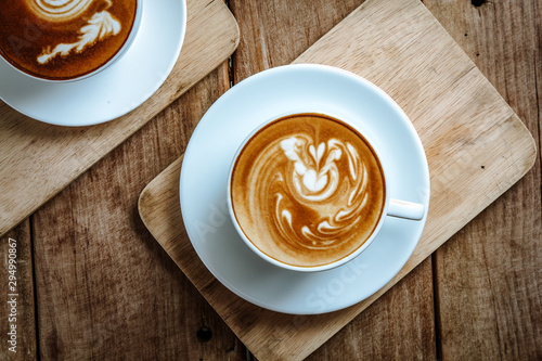 cup of hot latte art coffee on wooden table