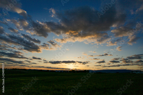 Sunrise and clouds over field