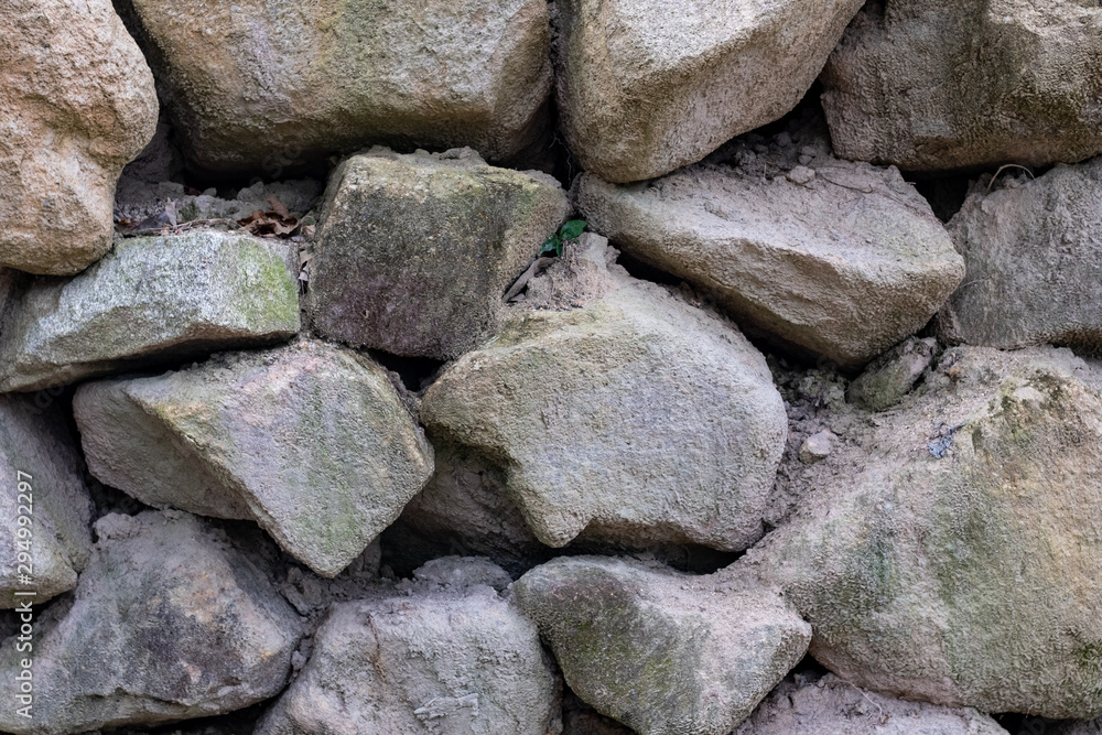Detail of dirty rough rock stone wall pattern texture nature background.