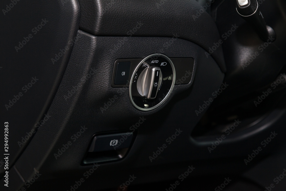 View to the black interior of car with dashboard, headlight adjust switch after cleaning before sale on parking