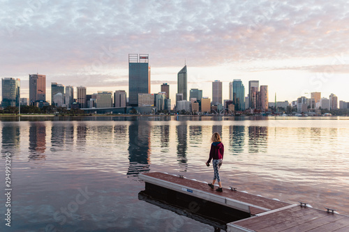 Girl walking along the South Perth foreshore at sunrise, taking in the views of the city as the sun rises over the Swan river. 