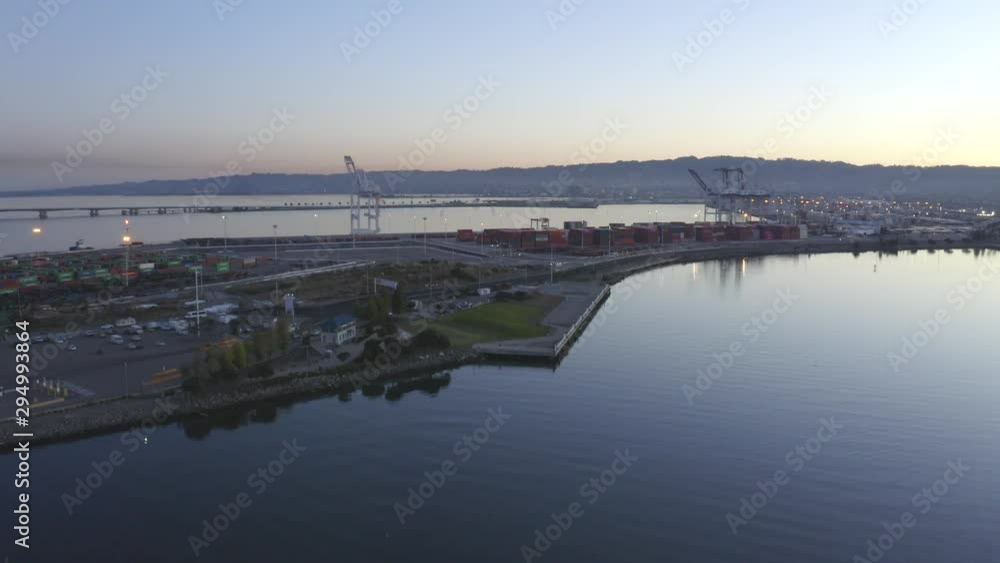 Slow push forward toward a large crane in the shipping port on a beautiful morning while the sun rises. Slow push forward toward a large crane in the shipping port on a beautiful morning while the sun rises.