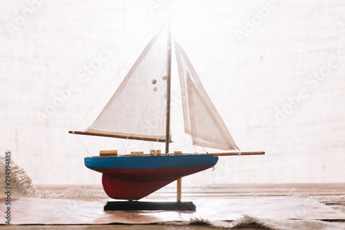 decorative ship with white sail on surface with hessian