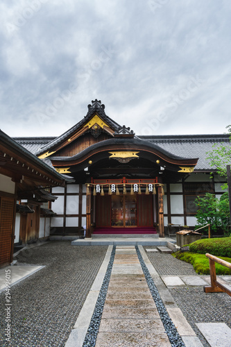 A beautiful traditional house or building within the Fushimi Inari Taisha shrine complex on a cloudy summer day. 