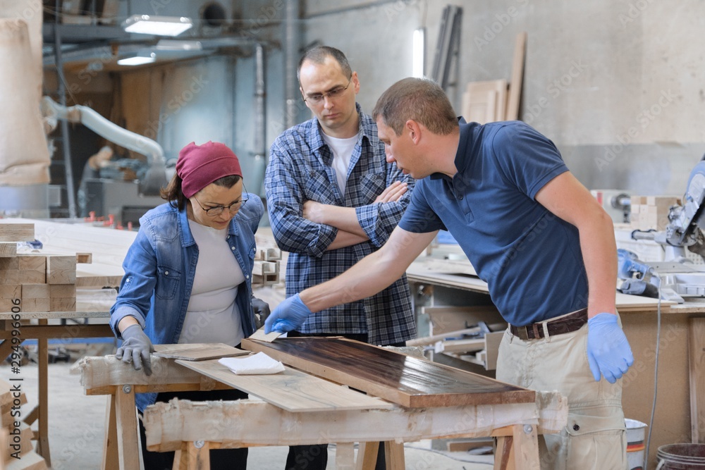 Group of people working in carpentry workshop Group of people working in carpentry workshop