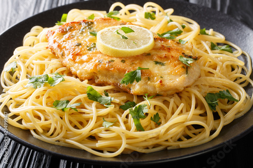Traditional chicken Francaise with spaghetti with lemon gravy close-up on a plate on the table. horizontal photo