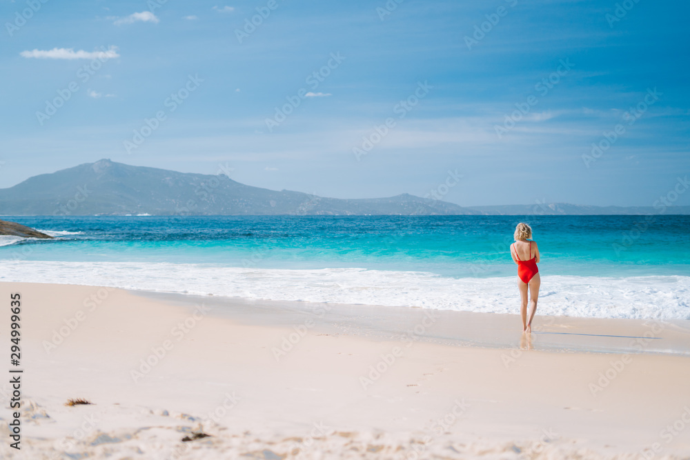 Young caucasian girl peacefully watching the waves crash on the shore of Little Beach. Located in Two Peoples Nature Reserve, Albany, Western Australia. 