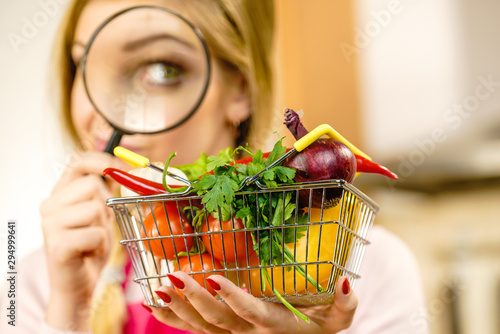 Woman investigating shopping backet with vegetables photo