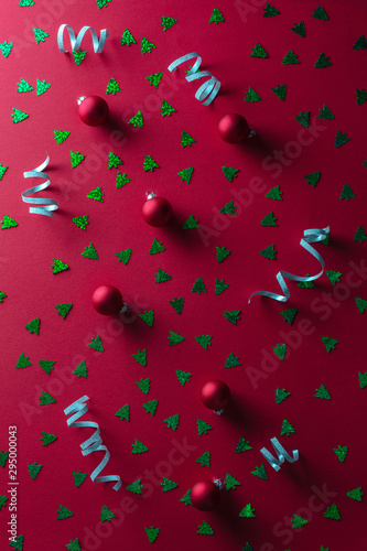 Red abstract christmas background with small christmas balls and tinsel.