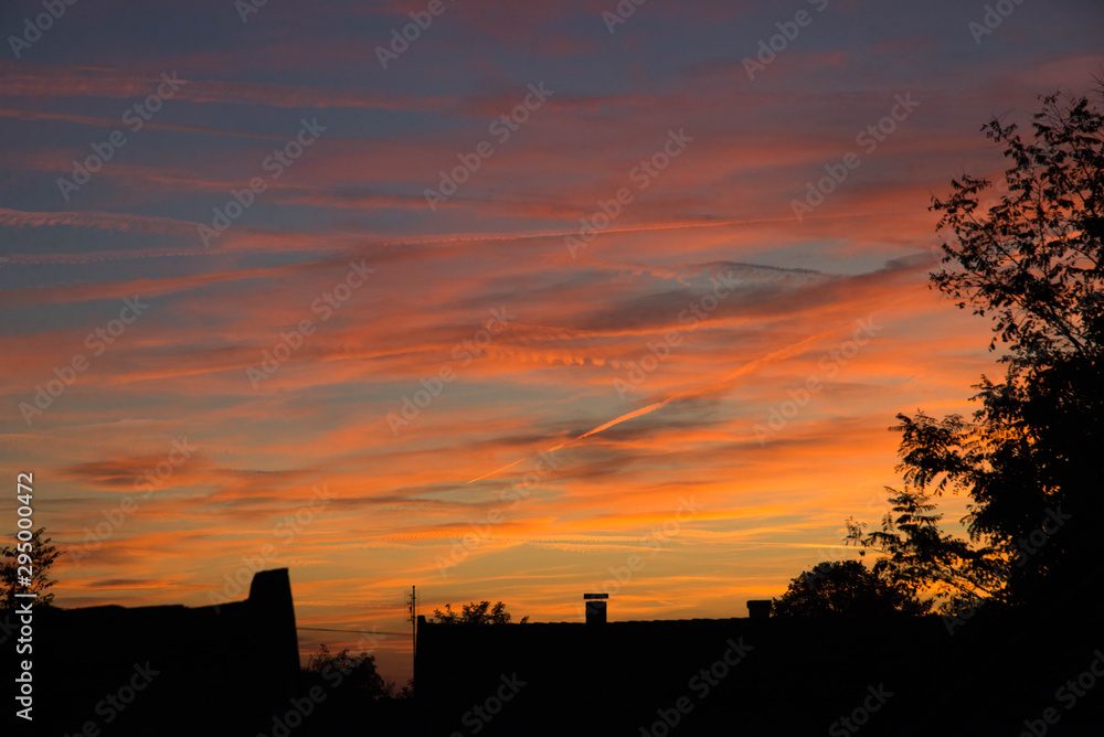 sunset scene of clouds with dark silhouettes