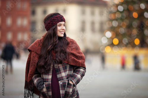 Beautiful joyful woman portrait in a city. Smiling girl wearing warm clothes and hat in winter or autumn