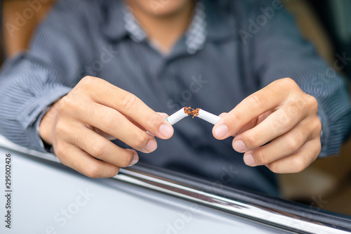 Young man sitting in the car and destroy cigarette by hand. Stop smoking in car concept