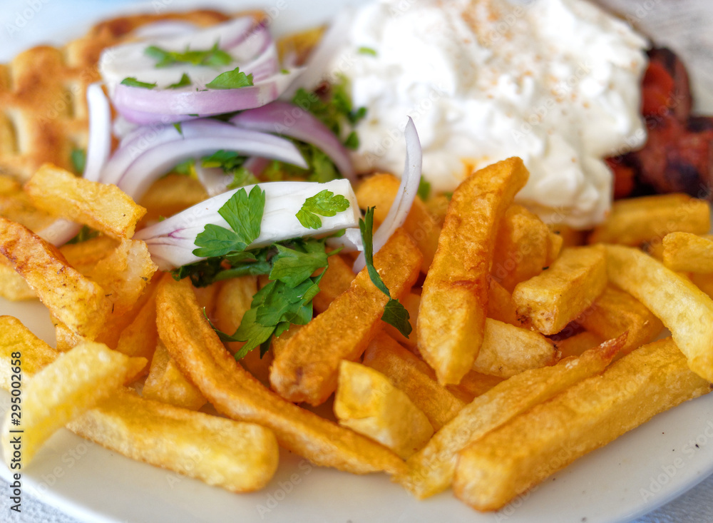 spicy kebab plate with pita bread, onions, fried potatoes, and tzatziki sauce spicy kebab plate with pita bread, onions, fried potatoes, and tzatziki sauce