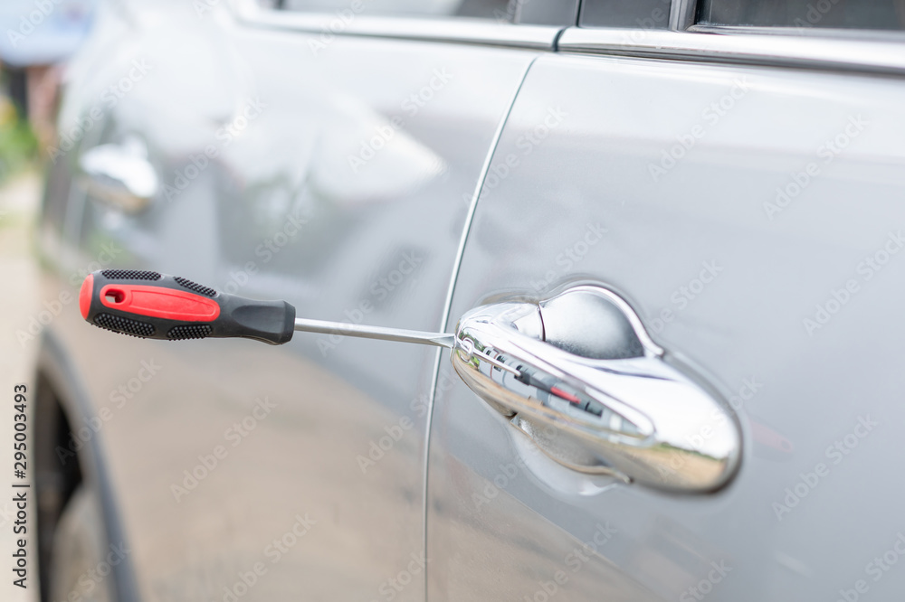 Car technician wearing white gloves and using screwdriver to fix, repair or open the door Car technician wearing white gloves and using screwdriver to fix, repair or open the door
