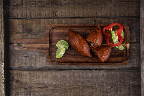 Arabic meat appetizer kibbeh isolated on rustic wooden table photo