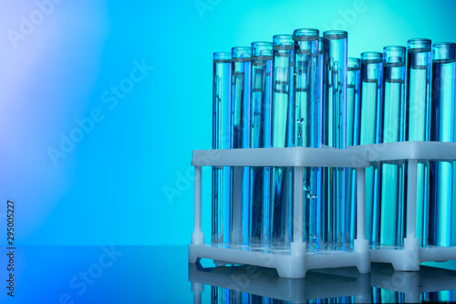 Row of test tubes with liquids on blue and green toned background