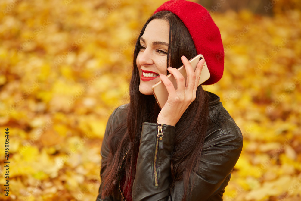 Outdoor shot of young attractive woman in autumn park using her phone for conversation with her boyfriendor hasband, being in good mood, looks happy, charming lady looking smiling straight ahead, Outdoor shot of young attractive woman in autumn park using her phone for conversation with her boyfriendor hasband, being in good mood, looks happy, charming lady looking smiling straight ahead,