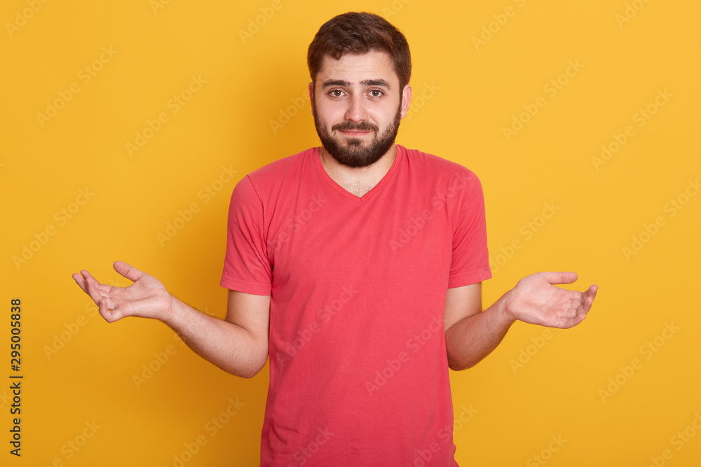 Portrait of beautiful caucasian young bearded man with dark hair, handsome male looking directly at camera with confused emotion, spreading hands, guy doesn't know what to answer his girlfriend. Portrait of beautiful caucasian young bearded man with dark hair, handsome male looking directly at camera with confused emotion, spreading hands, guy doesn't know what to answer his girlfriend.