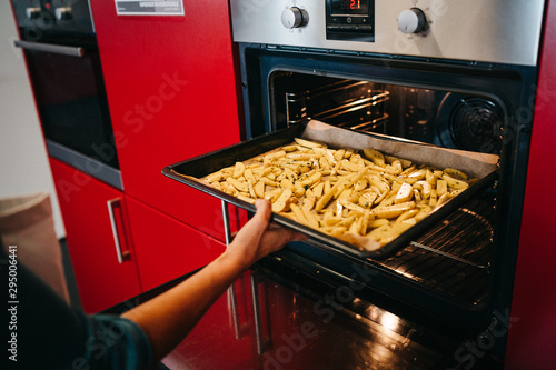 Kartoffenspalten in den Ofen schieben