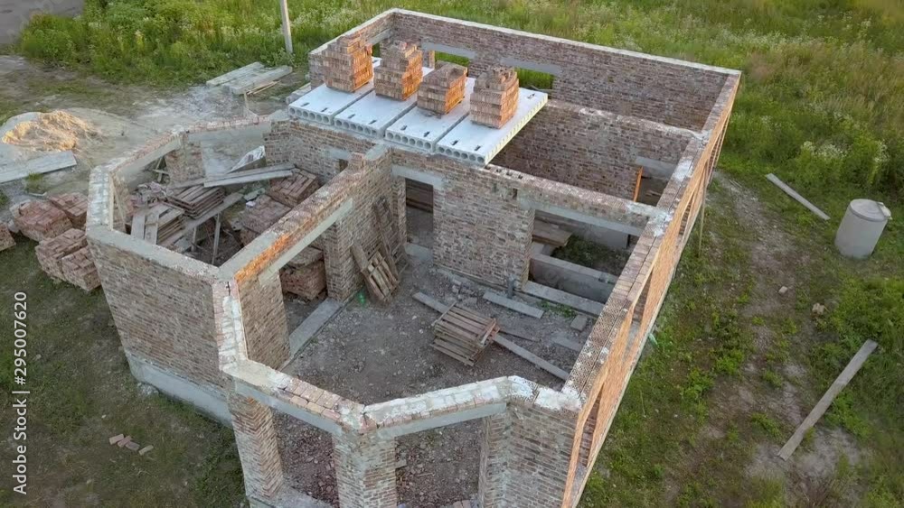 Aerial view od new brick unfinished house under construction. Aerial view od new brick unfinished house under construction.
