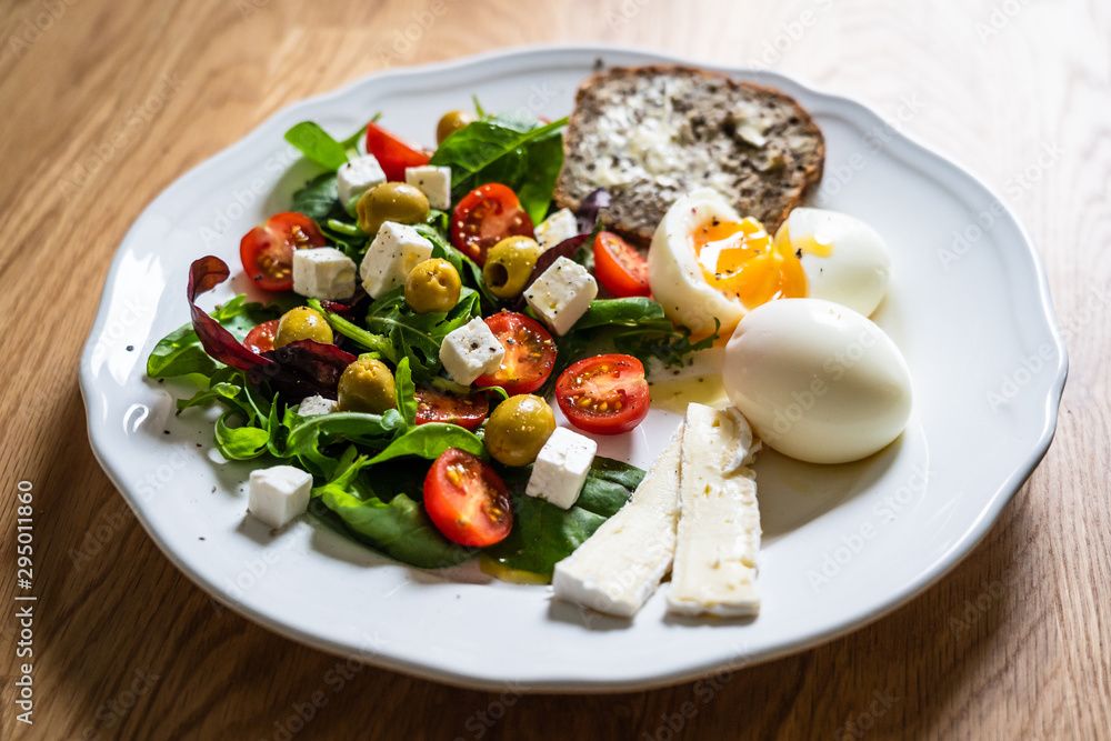 Greek salad with sandwich and boiled egg on white plate Greek salad with sandwich and boiled egg on white plate