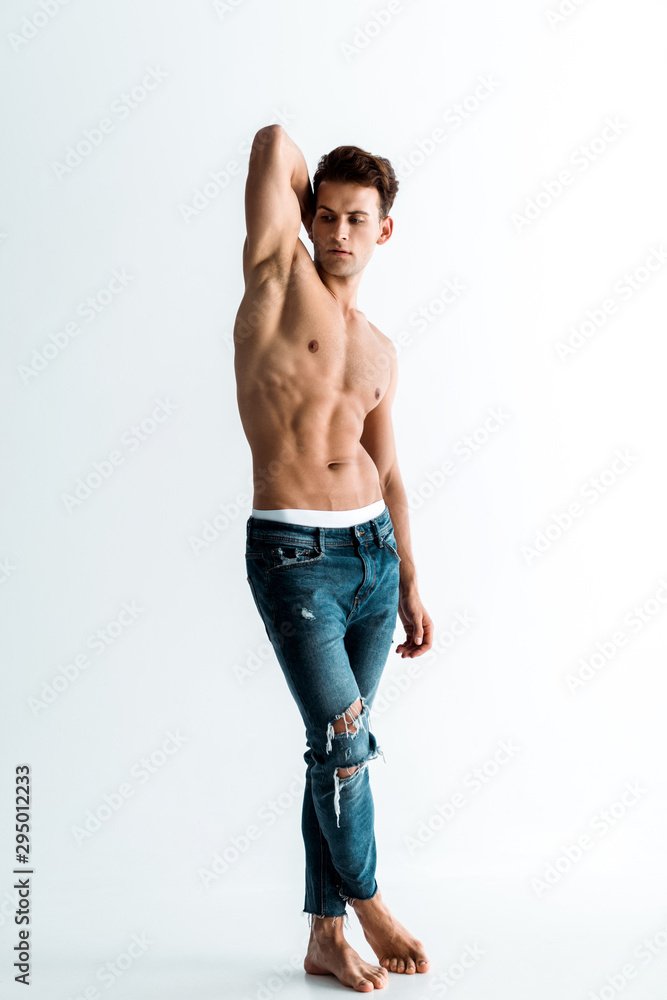 Foto de sexy man with barefoot standing in jeans on white do Stock | Adobe  Stock