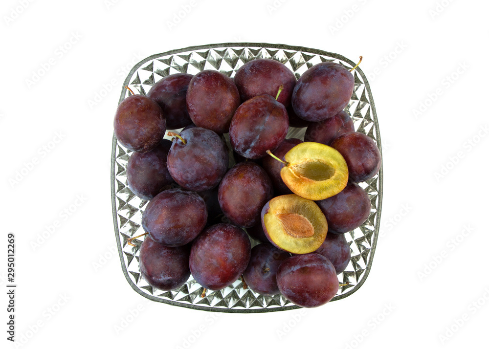 Fototapeta premium Fresh organic plums in glass vase isolated on white background. Still life of ripe and juicy fruits