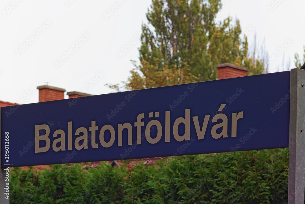 Balatonfoldvar sign at the railway station. The text on sign: Balatonfoldvar (village name). Beautiful white letters in the blue table. Balatonfoldvar, Hungary Balatonfoldvar sign at the railway station. The text on sign: Balatonfoldvar (village name). Beautiful white letters in the blue table. Balatonfoldvar, Hungary