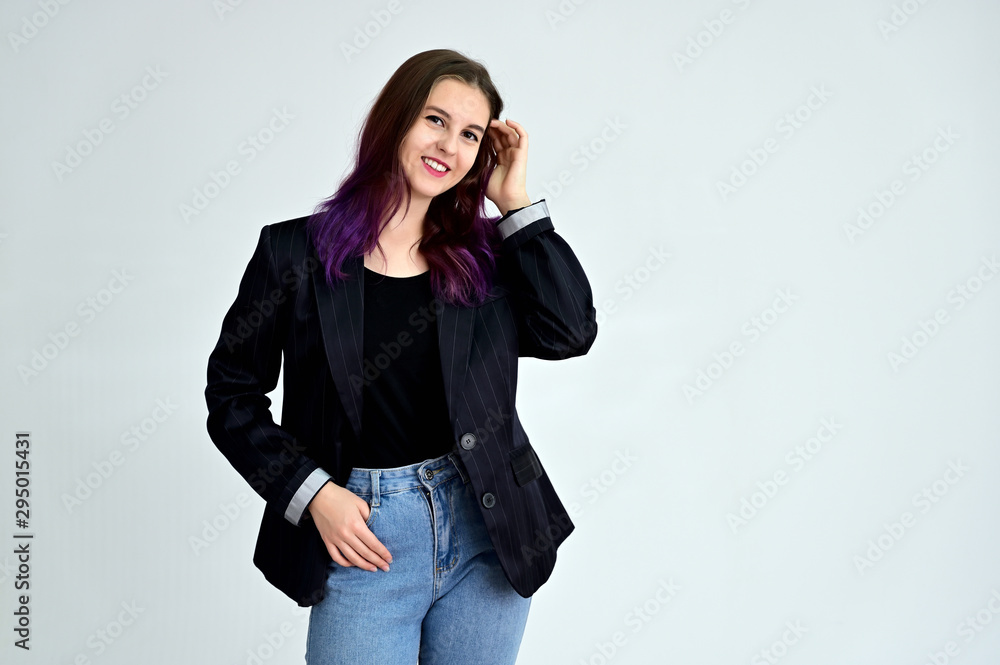 Studio portrait of a pretty brunette student girl with long hair in a jacket on a white background. Smiling at camera with emotions in various poses. Studio portrait of a pretty brunette student girl with long hair in a jacket on a white background. Smiling at camera with emotions in various poses.