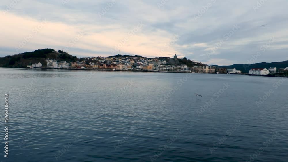 Panoramic view of Kristiansand village and lake with seagull flying during sundown evening Panoramic view of Kristiansand village and lake with seagull flying during sundown evening