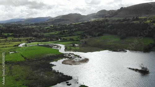 Rural scene with meadows and lake and river surrounded with hills. Aerial view - slide photo