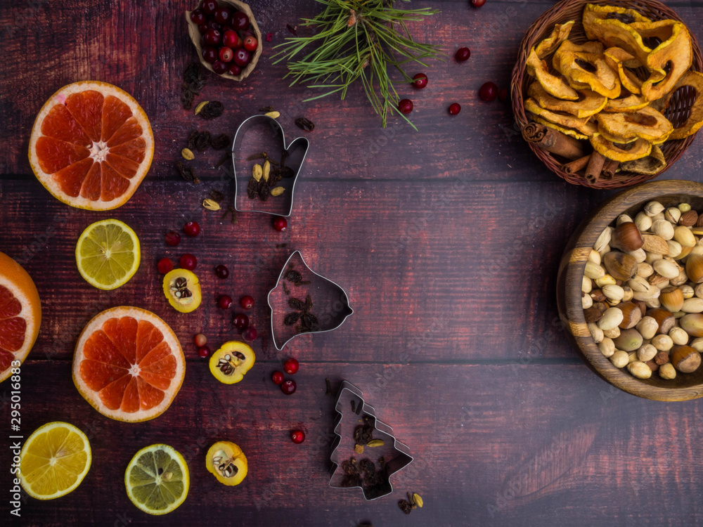 Mix of christmas spices, nuts, fresh and dried fruits, baking dish, christmas branch, selective focus Mix of christmas spices, nuts, fresh and dried fruits, baking dish, christmas branch, selective focus